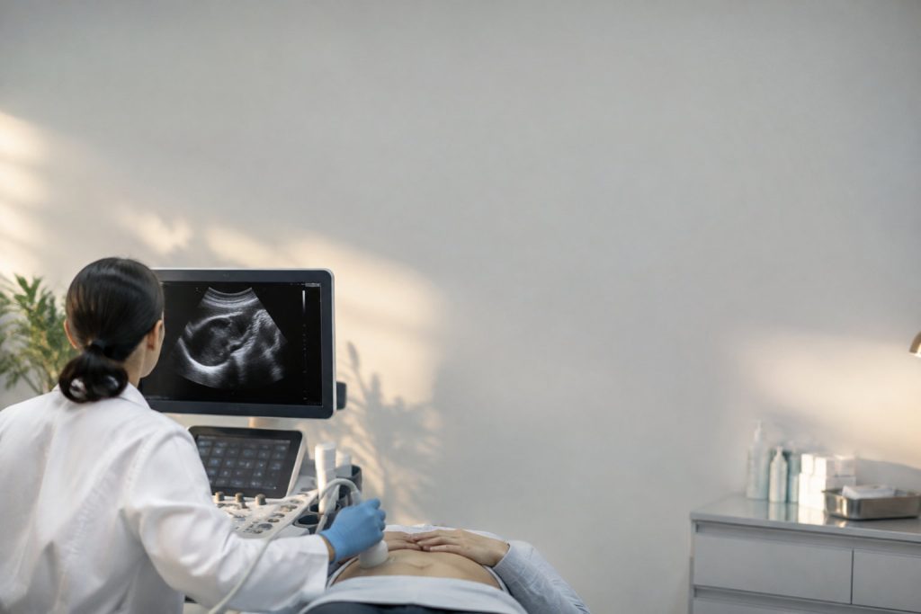 Une médecin effectue une échographie abdominale sur un patient dans un cabinet médical bien éclairé.